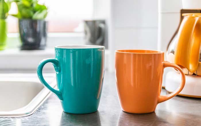 Two coffee mugs sitting on a table