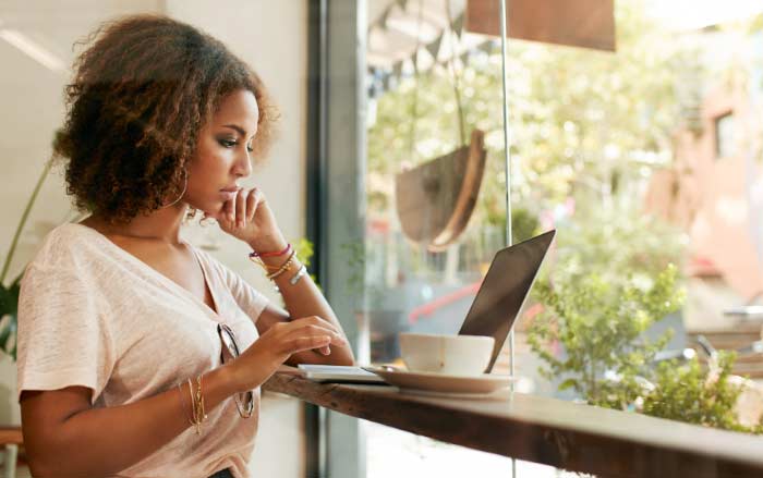 Woman looking at her laptop in a cafe